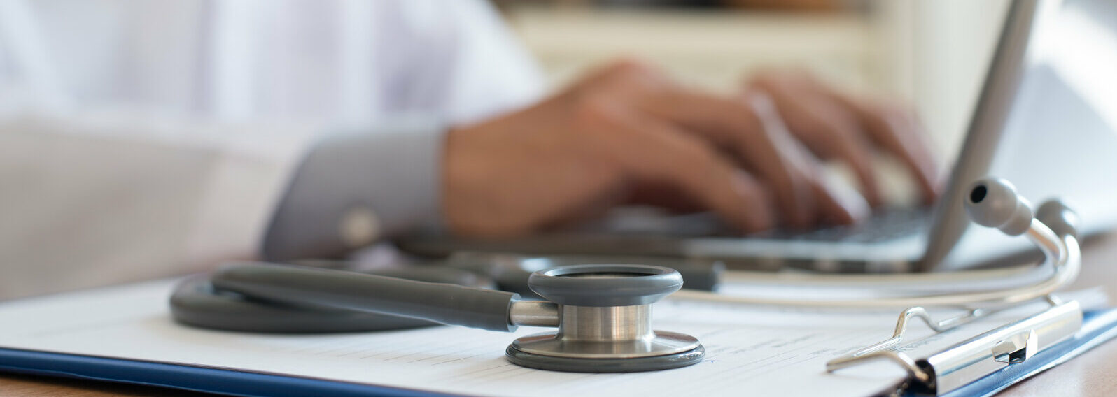 Doctor working on laptop computer and medical stethoscope on clipboard in hospital, telemedicine or teleconference, electronics health record system EHRs, electronics medical record system EMRs concept. 2022/03/AdobeStock_181868092-e1647982936418.jpeg 