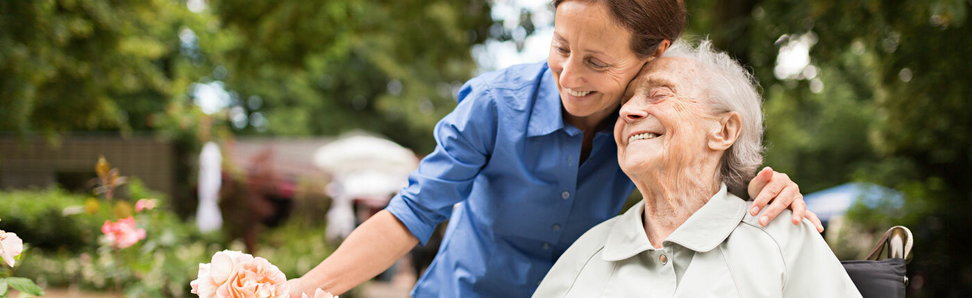 woman embracing elderly woman and smiling