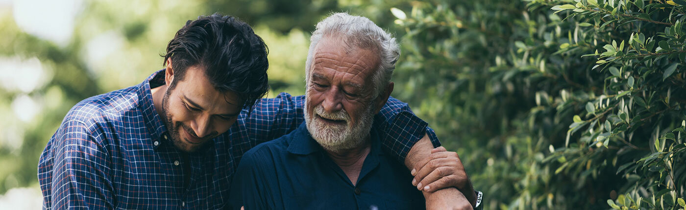 elderly man walking with son outside