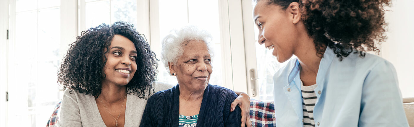 african american woman talking with african american elderly mom and young daughter