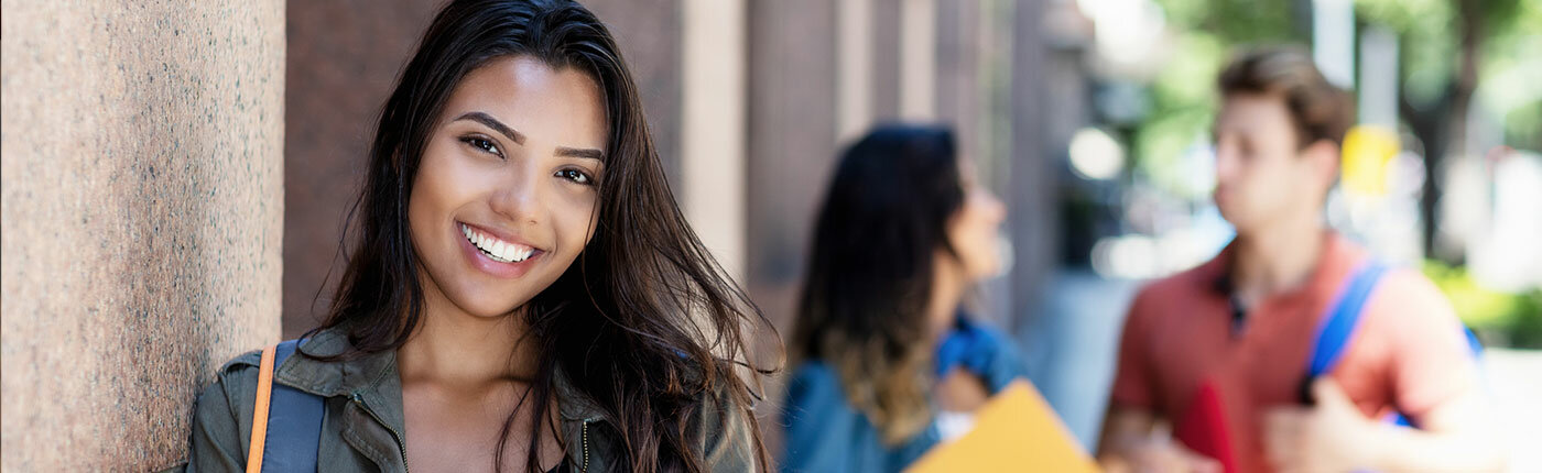 girl smiling with classmates in background