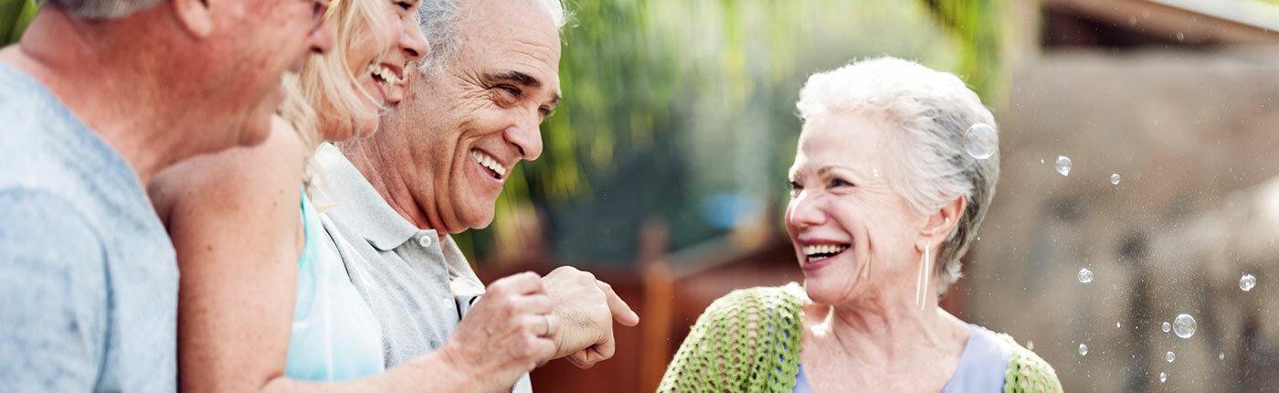 group of older people laughing outside together