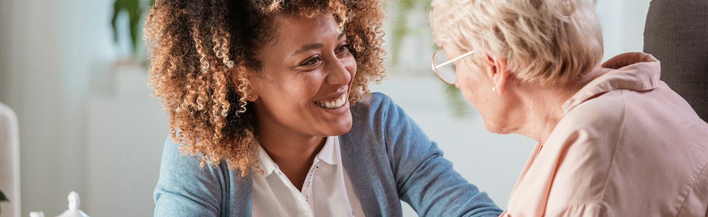 african american woman comforting elderly white woman, smiling